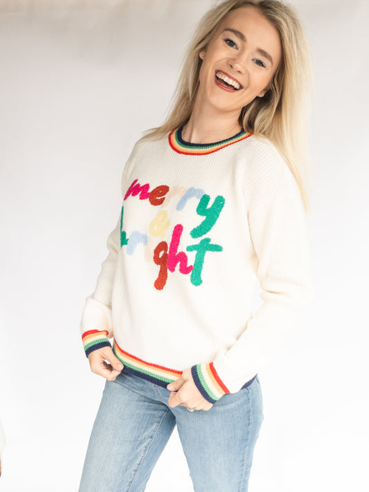 Woman wearing a merry & bright christmas sweater against a white backgroud