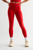 Woman wearing red workout leggings on a plain background