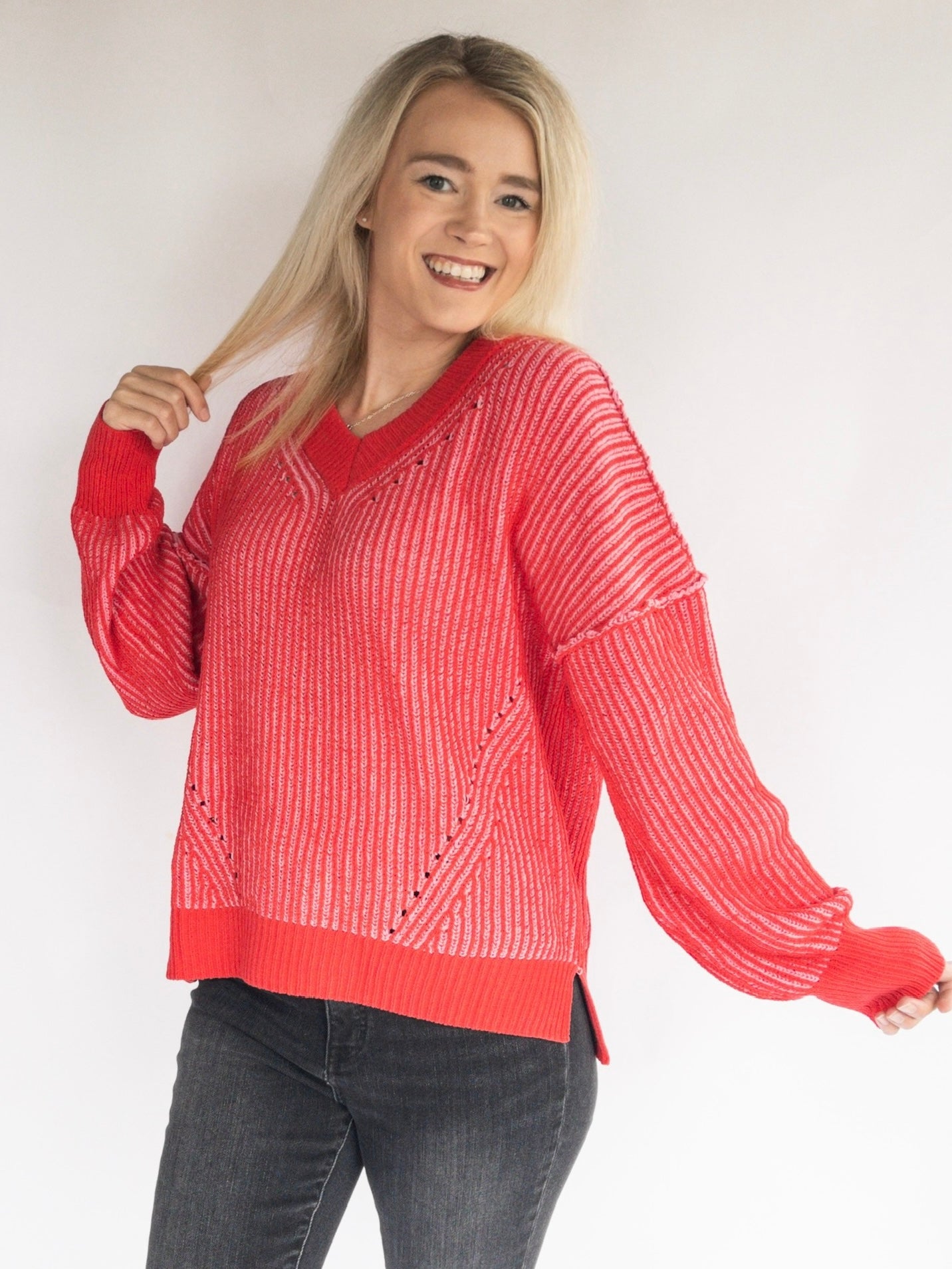 Woman wearing a red sweater with a white background