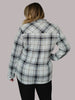 Person wearing a plaid shirt with a gray background
