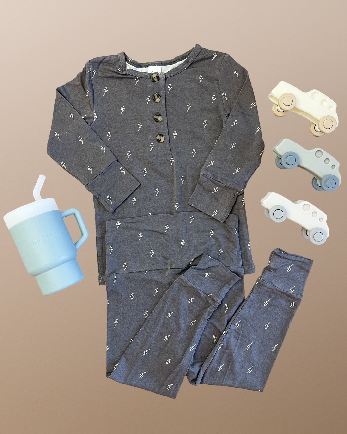 Lou Lou & Company Everett set with lighting bolts, accompanied by a blue tumbler and toy cars.